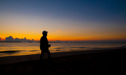 Fototapeta na wymiar silhouette of a man walking on the sea