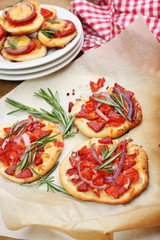 Small pizzas on baking paper close up