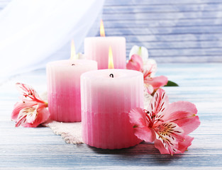 Obraz na płótnie Canvas Beautiful candles with flowers on wooden background