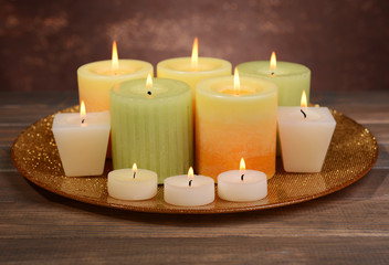 Fototapeta na wymiar Beautiful candles on table on brown background