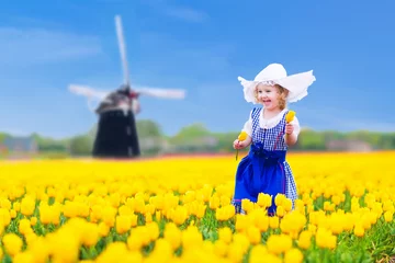 Fotobehang Beautiful dutch girl in tulip field in Holland © famveldman