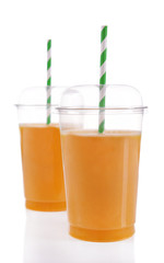 Orange juice in fast food closed cups with tubes isolated