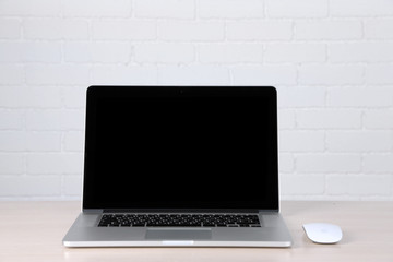 Obraz na płótnie Canvas Modern laptop on table, on white wall background