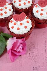 Valentine red velvet cupcakes on wood background