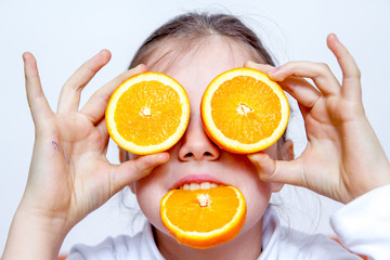 Little girl playing with orange fruits