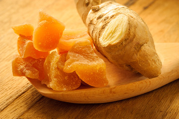 Closeup root and candied ginger on wooden table