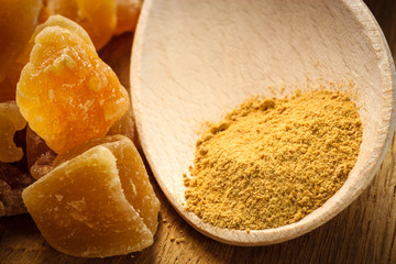 Candied and ground ginger on rustic table