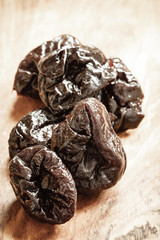 dried plums prunes on wooden table