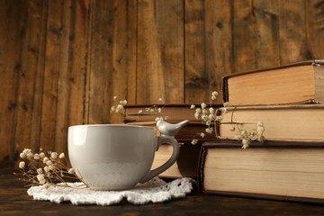 Cup of tea with books on wooden background