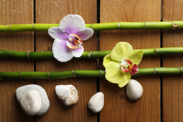 Orchid flowers  and bamboo with pile stones on wooden