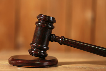 Wooden judges gavel on wooden table, close up