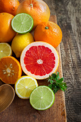 Fototapeta na wymiar Halves of citrus fruits on wooden background. Orange, grapefruit