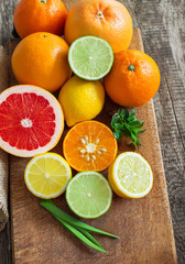 Halves of fresh citrus fruits on wooden background. Orange, grap