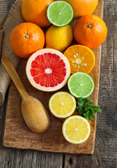 Halves of fresh citrus fruits on wooden background. Orange, grap