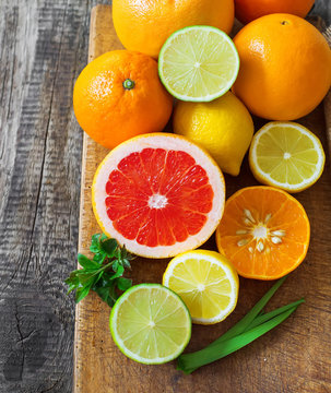 Halves of citrus fruits on wooden background. Orange, grapefruit