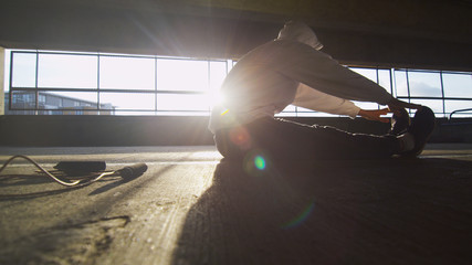 Hooded athlete stretching before or after a workout