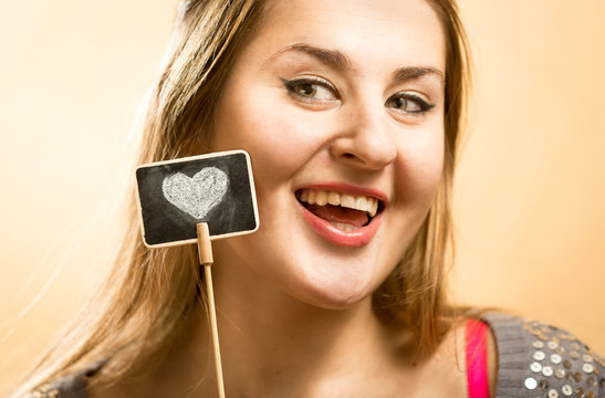 Smiling Woman Posing With Decorative Chalk Boar With Drawn Heart