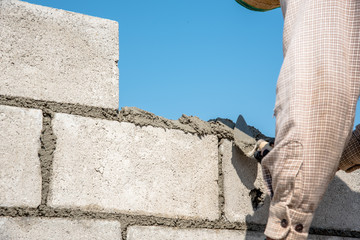worker build concrete wall by cement block and plaster 