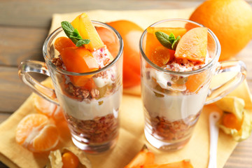 Healthy layered dessert with muesli and fruits on table