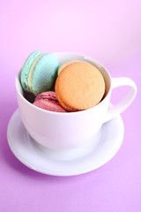 Assortment of gentle colorful macaroons in colorful mug