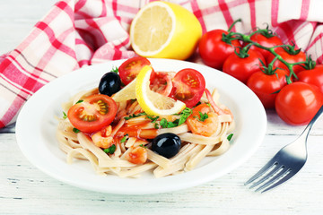 Tasty pasta with shrimps, black olives and tomato sauce