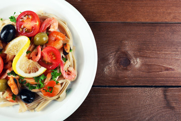 Tasty pasta with shrimps, mussels, black olives and tomato