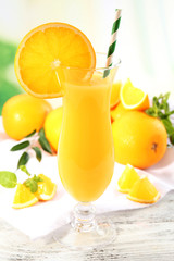 Glass of orange juice with straw and slices