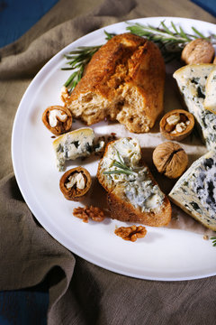Blue cheese with sprigs of rosemary, bread and nuts