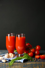 Glasses of tasty tomato juice and fresh tomatoes