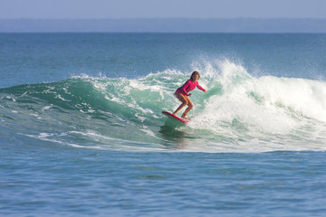 Surfer girl on the wave, Indonesia.