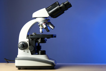 Microscope on table, on color background