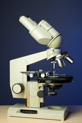 Microscope on table, on color background