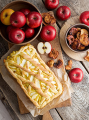 Apple pie on a board with fresh apples