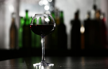 Glass of red wine in bar on blurred background