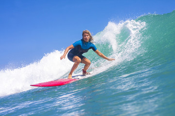 Surfer girl on the wave, Indonesia. - obrazy, fototapety, plakaty