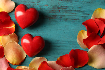 Rose petals and decorative hearts on wooden background