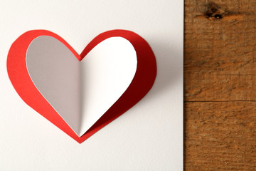 Beautiful paper heart on white paper background, close-up