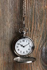 Silver pocket clock on wooden background