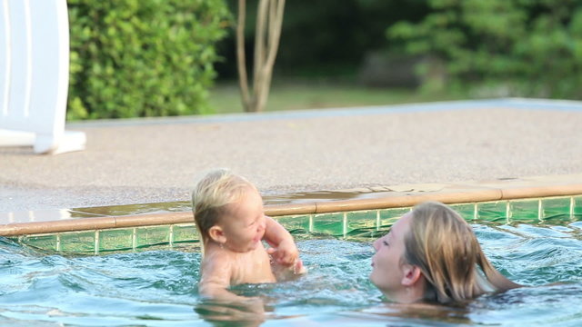 child jump to mother in swimming pool	