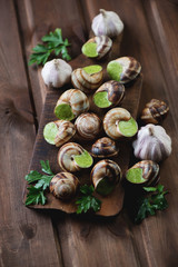 Rustic wooden cutting board with escargots de Bourgogne