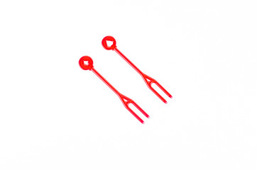 red plastic food skewer on white background