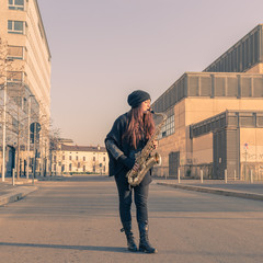Beautiful young woman playing tenor saxophone