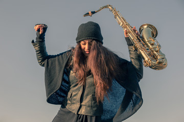 Beautiful young woman with her saxophone