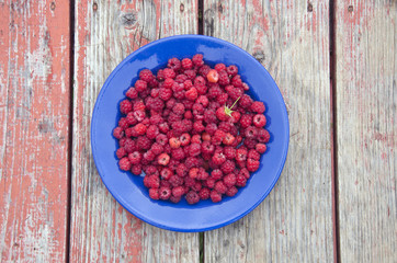 fresh raspberry fruits on blue ceramic plate