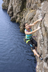 Female extreme climber conquers steep rock