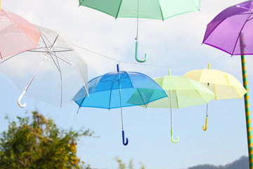 Fototapeta na wymiar Colorful of umbrellas hang on the sky with blue sky background