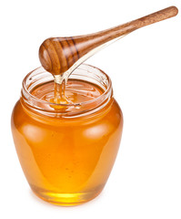 Honey flowing into glass jar. File contains clipping paths.