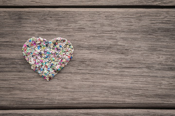Colorful love heart on wood background with space for text
