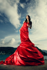 beautiful young woman in red long dress outdoor