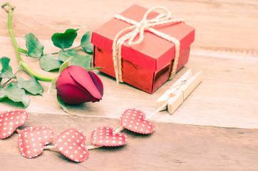 roses and gift box on wooden background